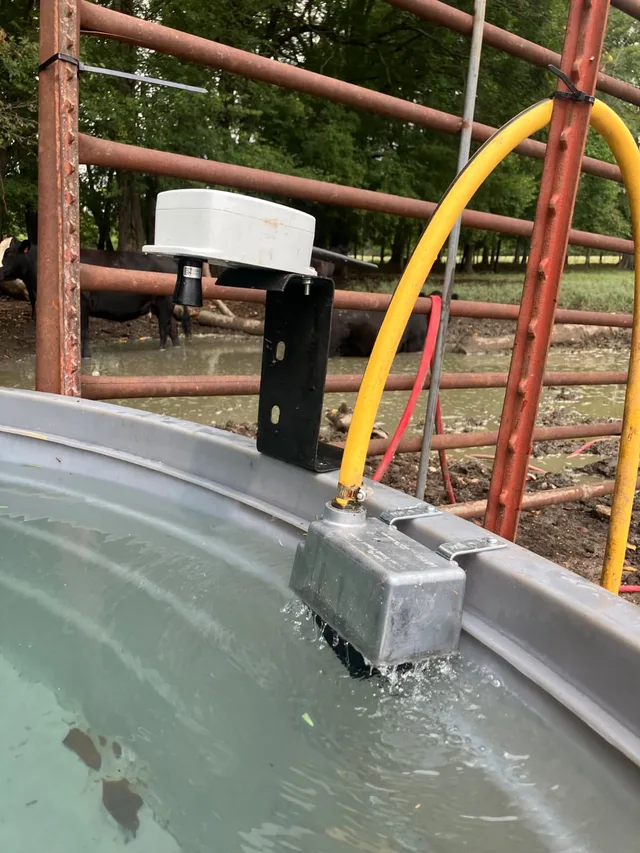 Close view of the ultrasonic sensor and bracket over the tank rim, with the float valve refilling the tank below