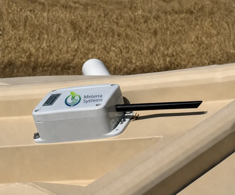 Meterra-branded wireless ultrasonic tank level sensor mounted on the edge of a water tank