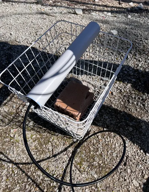 The stainless pressure sensor in its wire basket with a weight, before it goes into the water