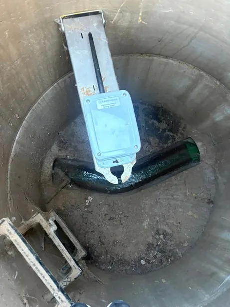 View down a manhole showing the monitor on its bracket above the channel